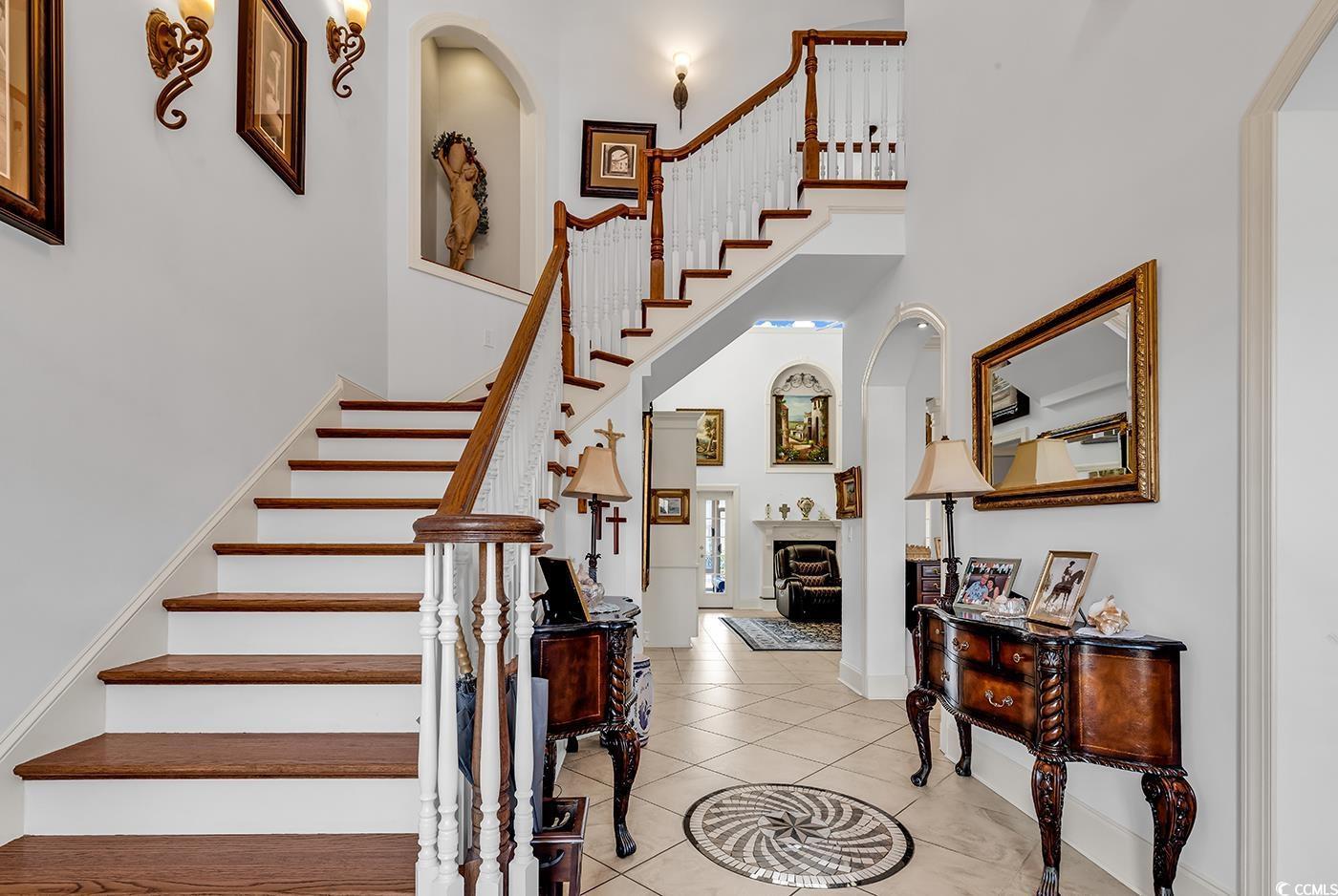 Image 3: Staircase featuring a high ceiling, arched walkway