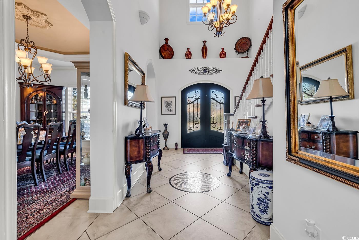 Image 4: Foyer with a chandelier, arched walkways, light ti