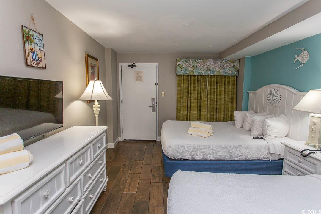 Image 4: Bedroom with baseboards and dark wood finished flo