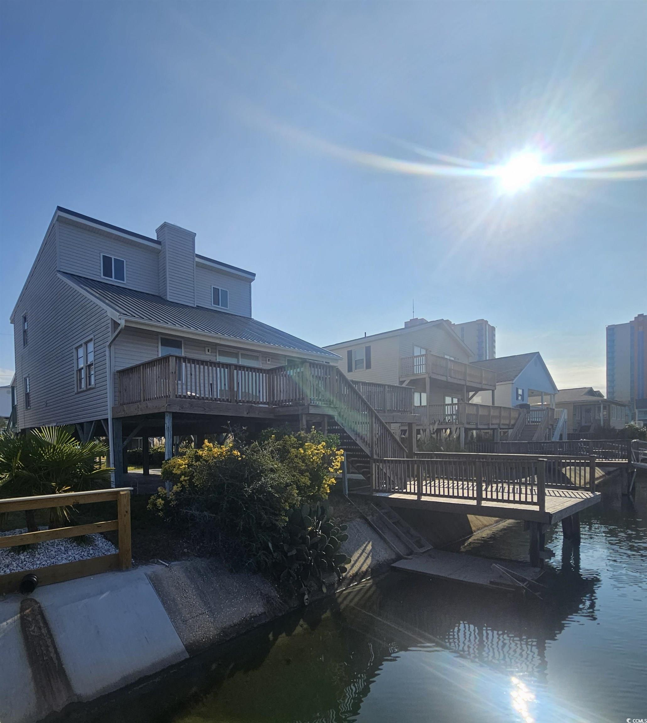 Image 3: Back of house featuring a deck with water view, a Image 3: Back of house featuring a deck with water view, a