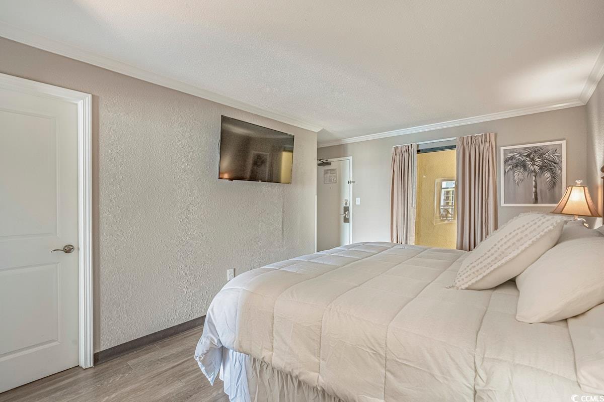 Image 4: Bedroom with wood finished floors, a textured wall Image 4: Bedroom with wood finished floors, a textured wall