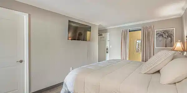Image 4: Bedroom with wood finished floors, a textured wall
