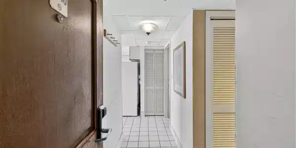 Image 3: Hallway with light tile patterned flooring and a p