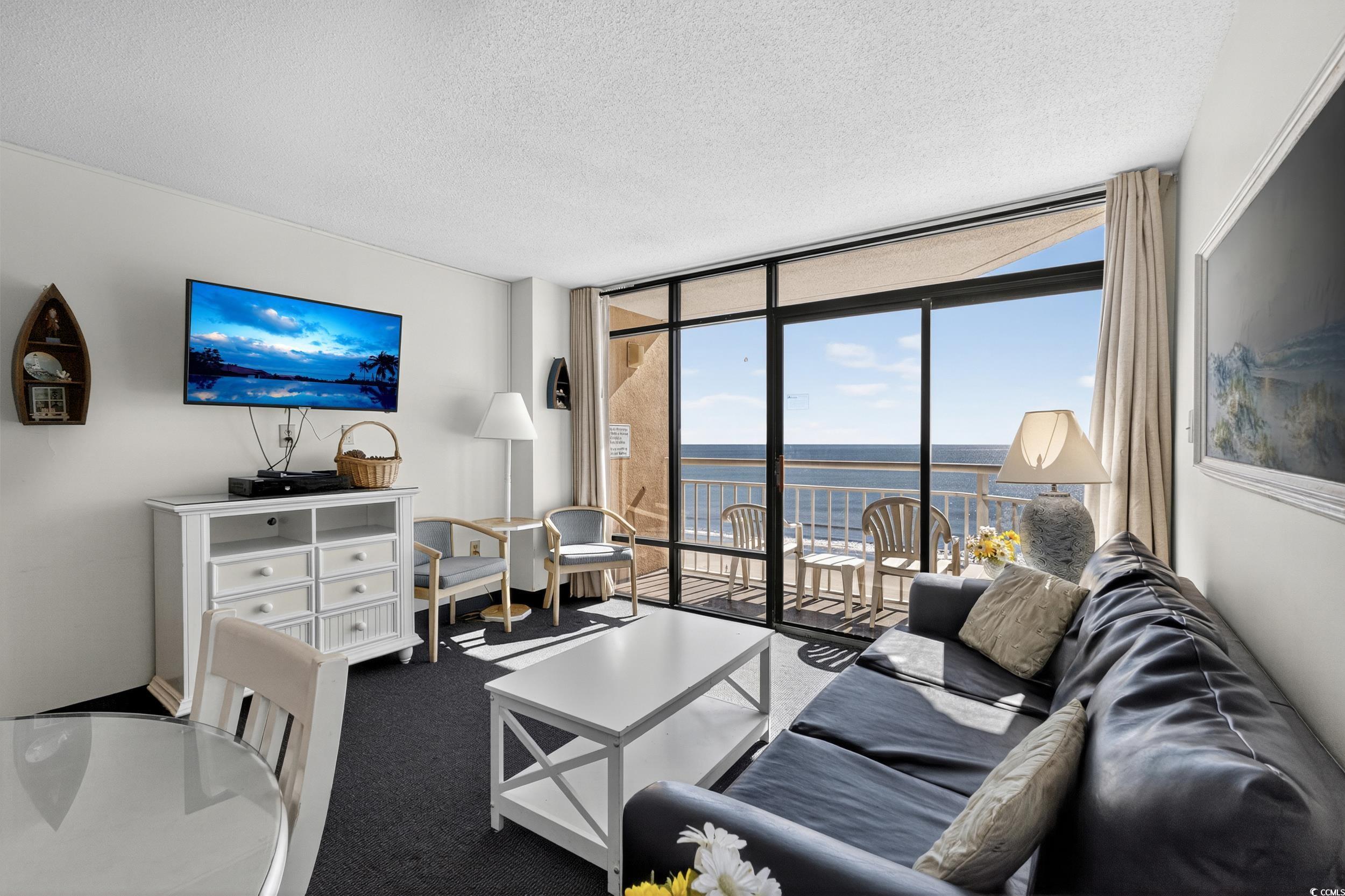 Image 4: Living area with expansive windows, a textured cei Image 4: Living area with expansive windows, a textured cei