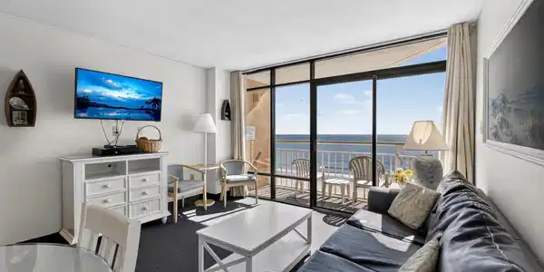 Image 4: Living area with expansive windows, a textured cei
