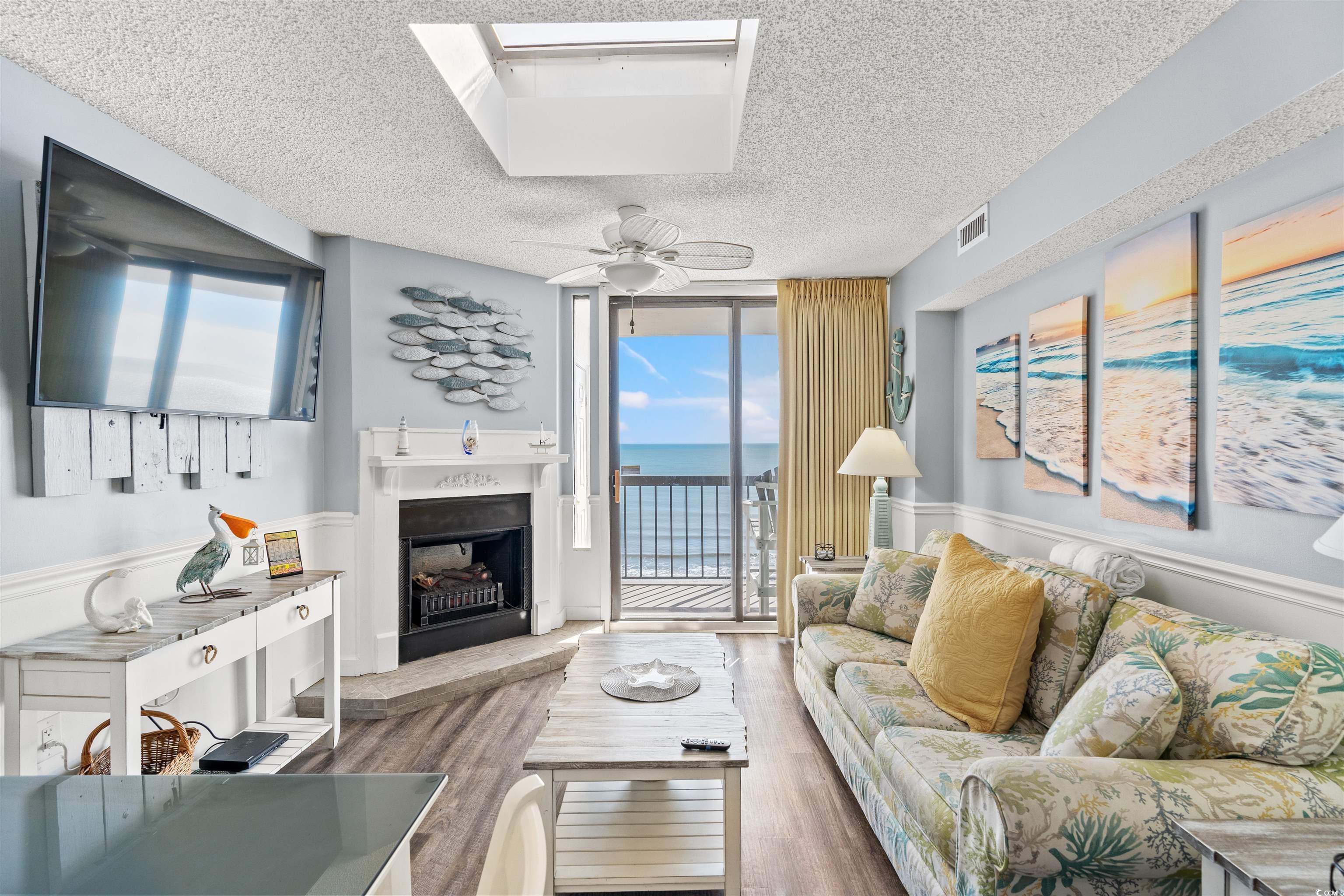 Image 2: Living room featuring a wall of windows, a firepla