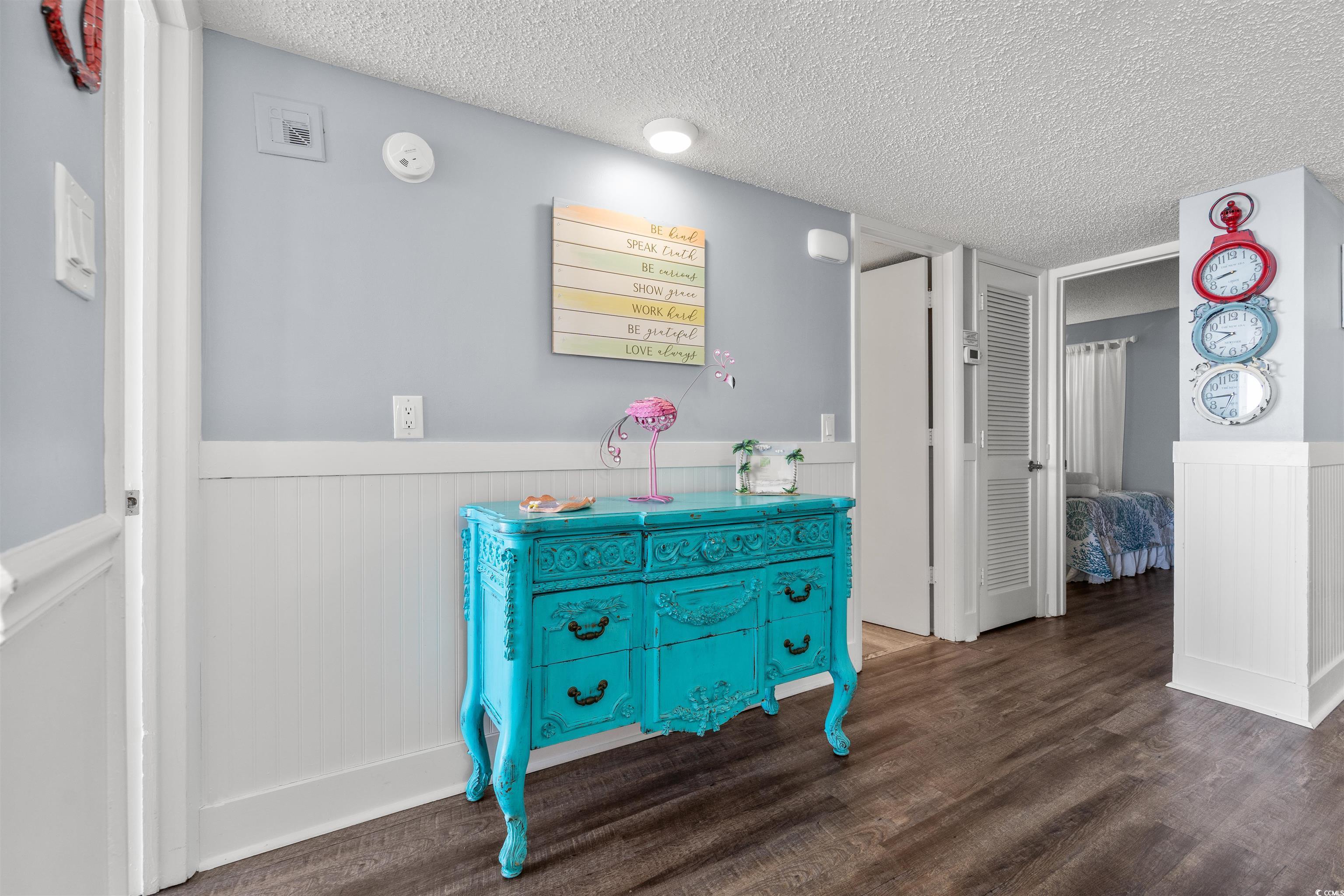 Image 4: Hall featuring wainscoting, a textured ceiling, an
