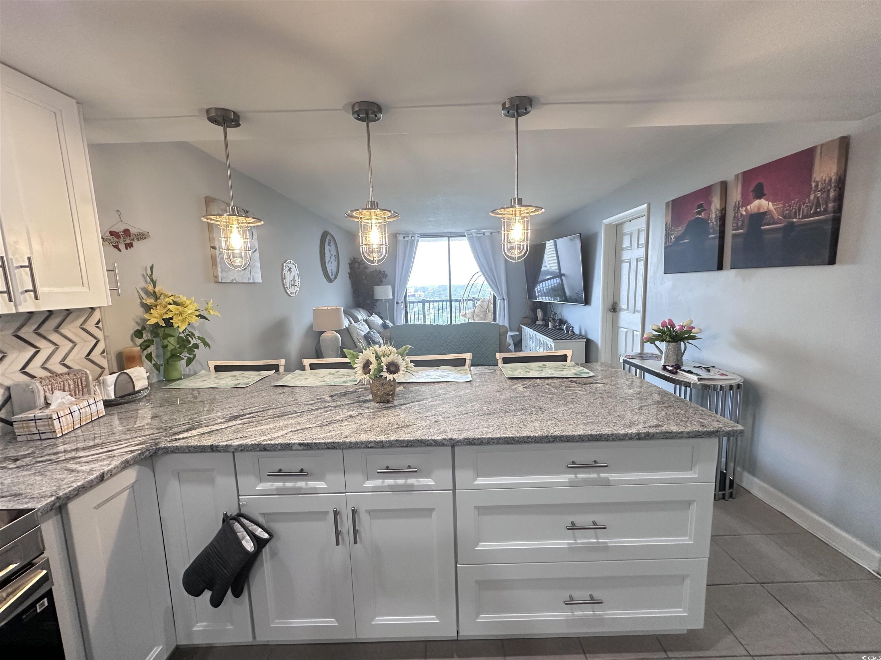 Image 4: Kitchen featuring white cabinets, a peninsula, lig Image 4: Kitchen featuring white cabinets, a peninsula, lig