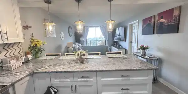 Image 4: Kitchen featuring white cabinets, a peninsula, lig Image 4: Kitchen featuring white cabinets, a peninsula, lig