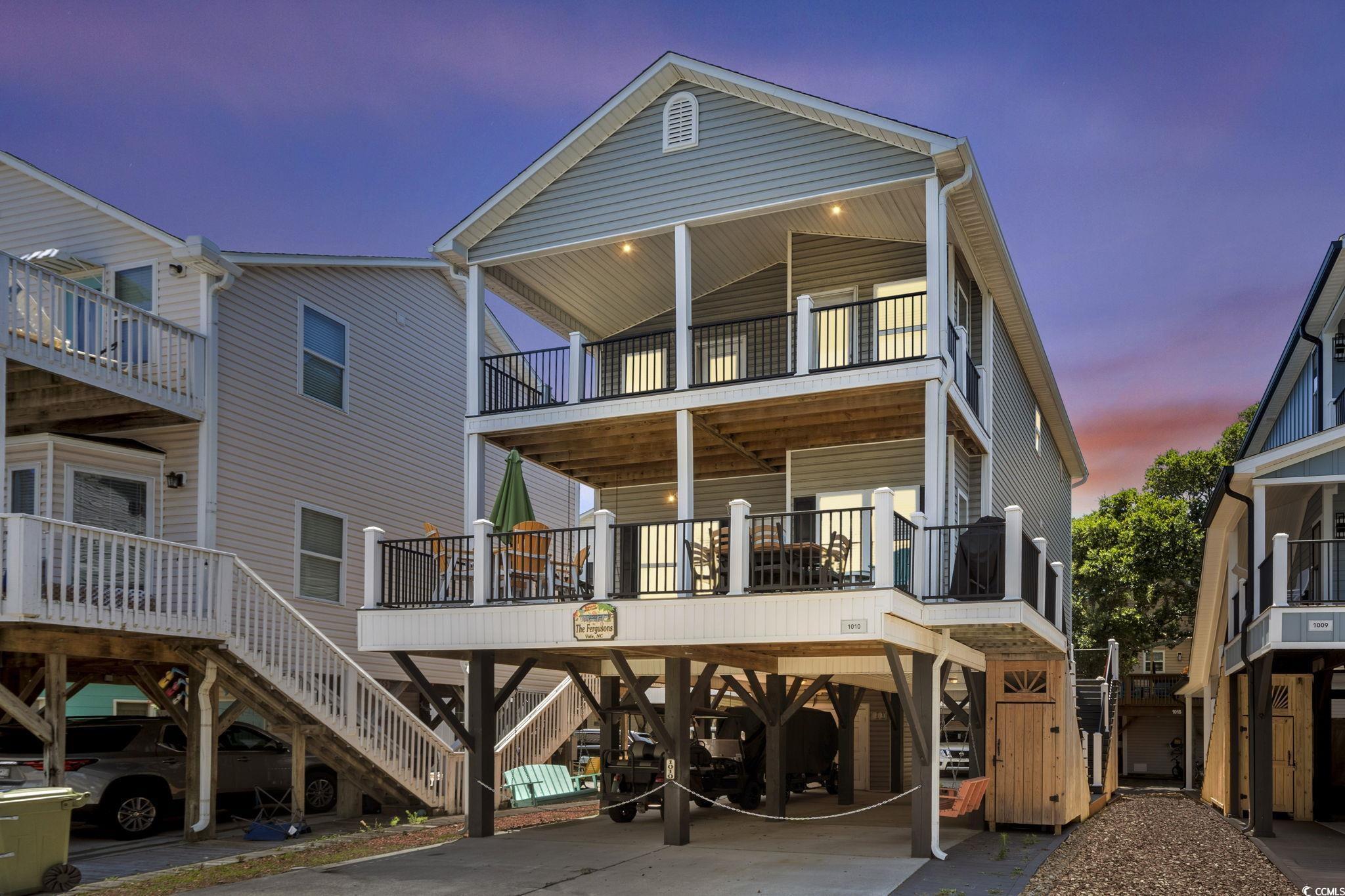 Image 1: Back of house at dusk with a carport, a balcony, a Image 1: Back of house at dusk with a carport, a balcony, a