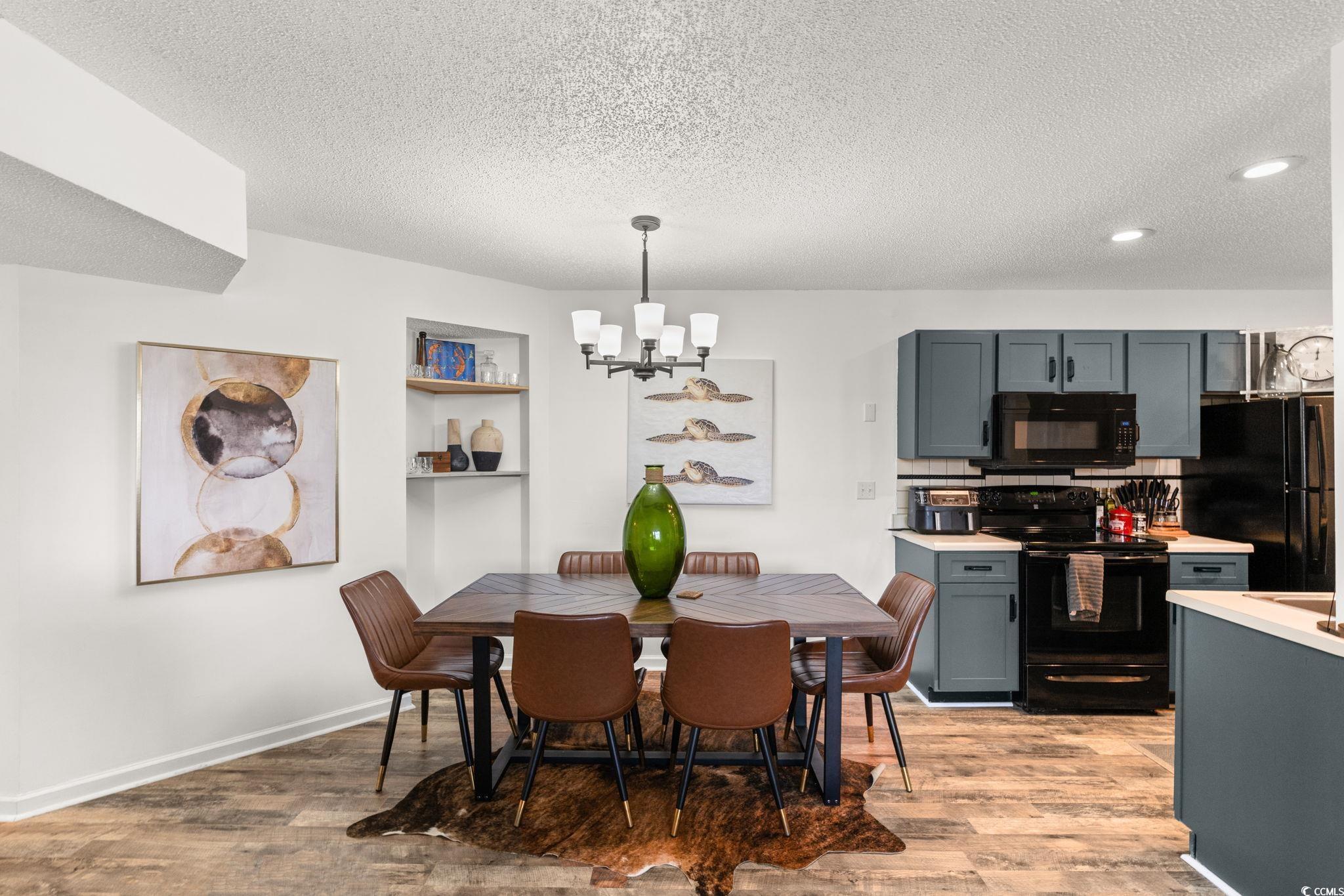 Image 3: Dining space featuring a chandelier, a textured ce Image 3: Dining space featuring a chandelier, a textured ce