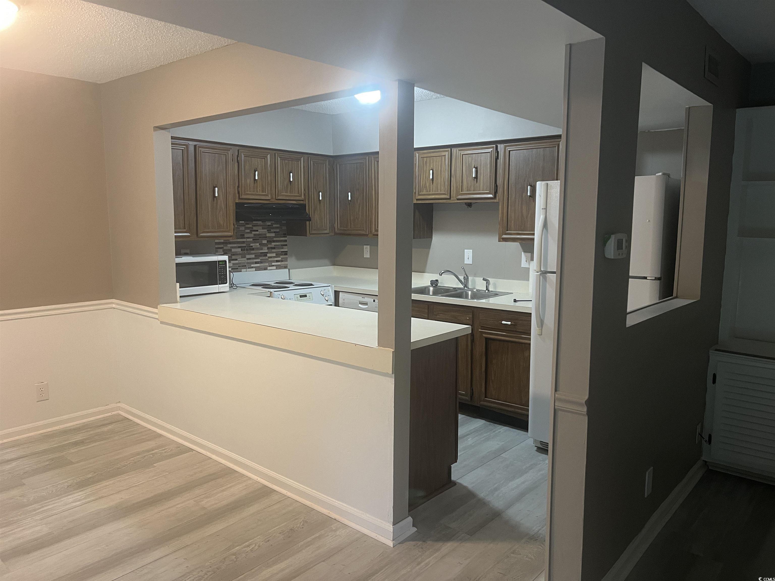 Image 3: Kitchen with stainless steel microwave, light wood