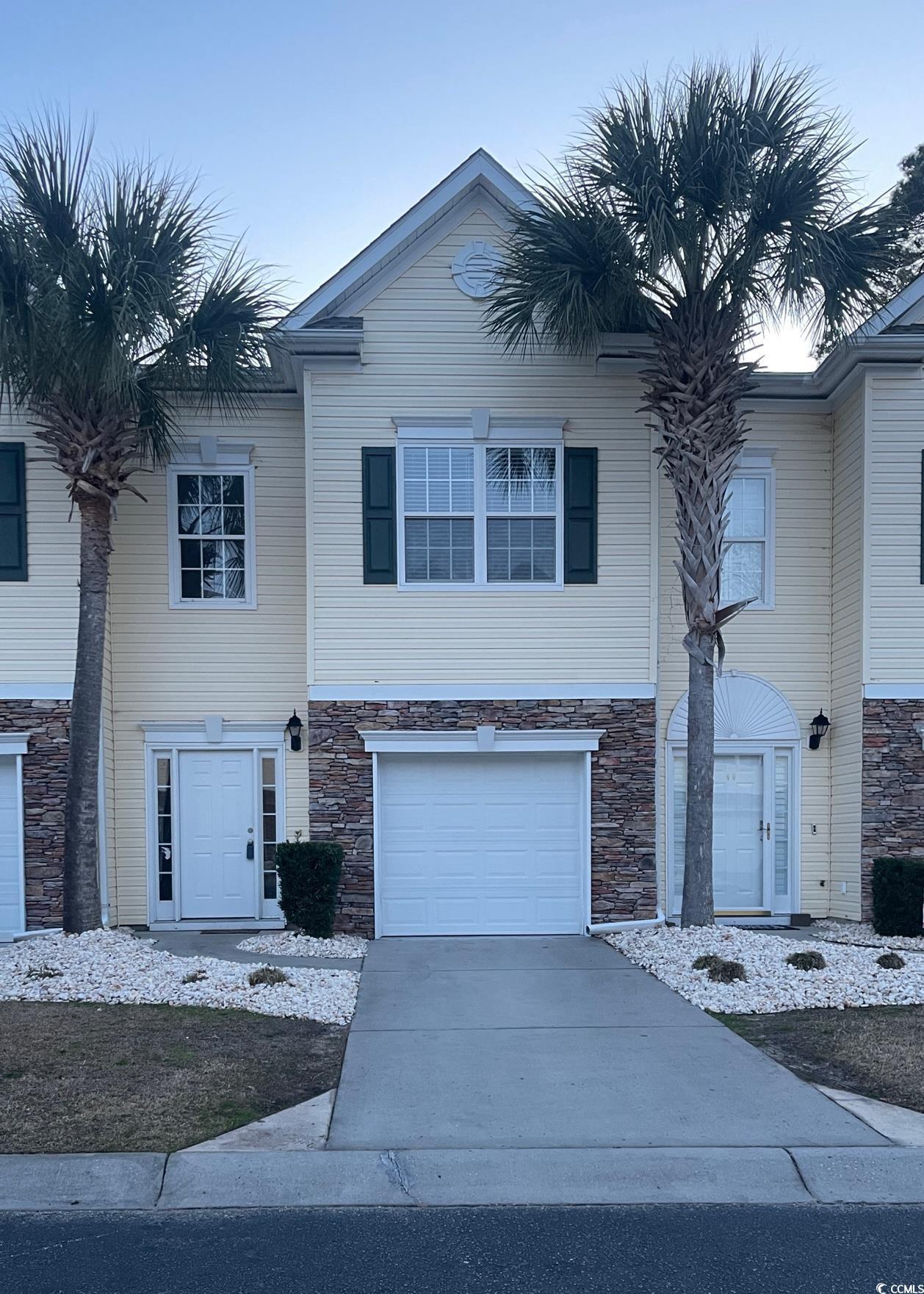 Image 1: View of front of home featuring stone siding, conc