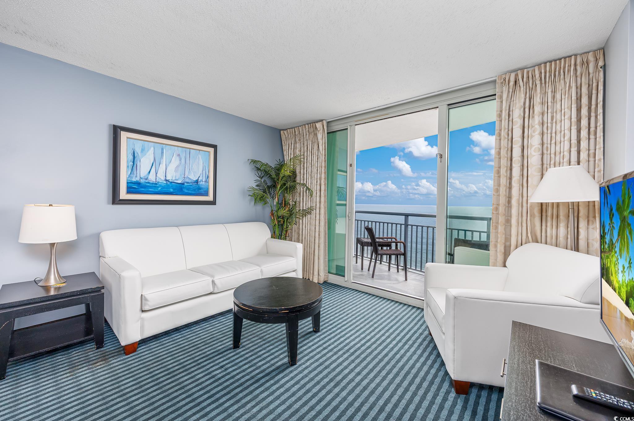 Image 4: Carpeted living area with floor to ceiling windows