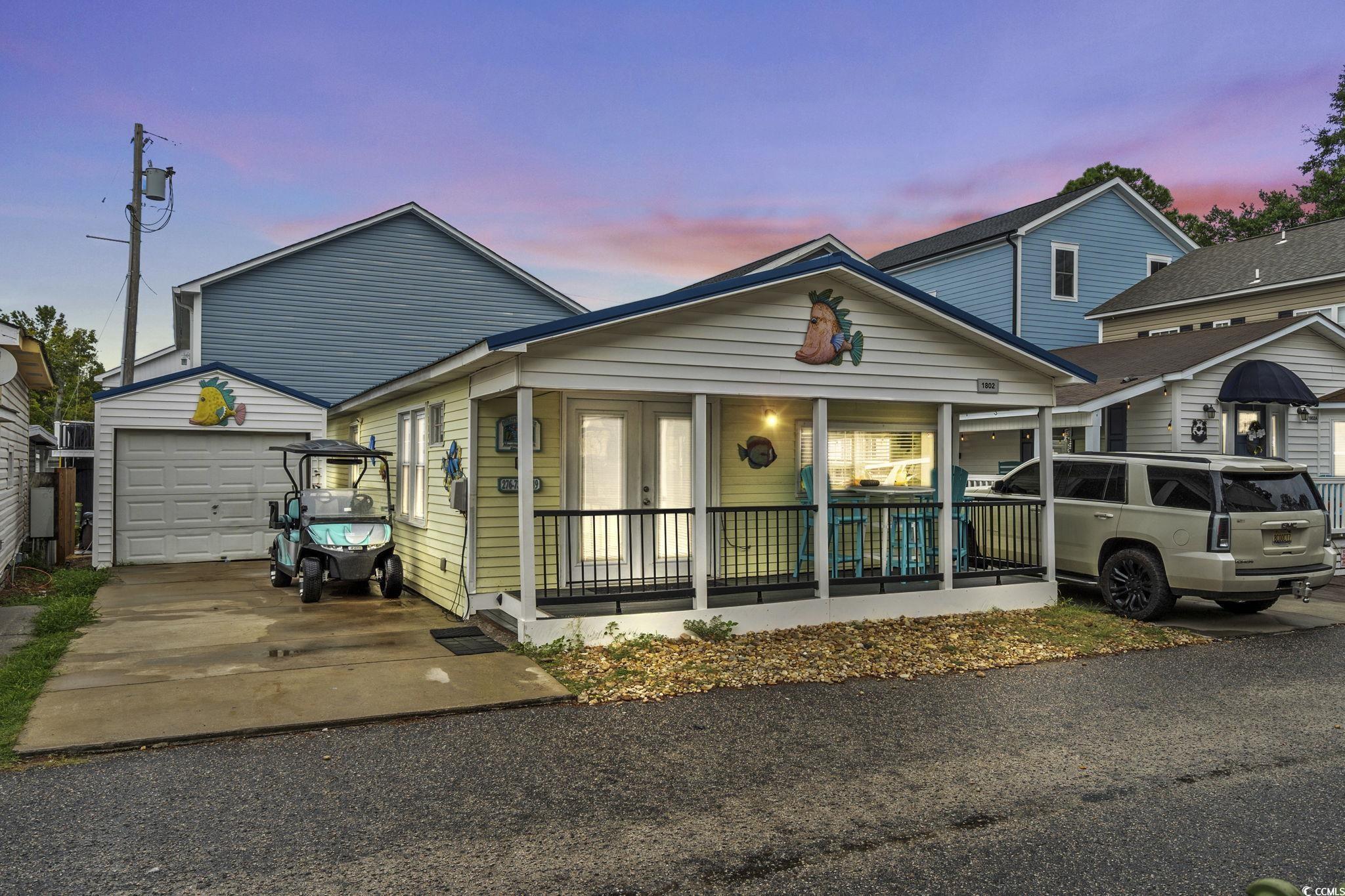 Image 1: View of front facade with a garage, concrete drive
