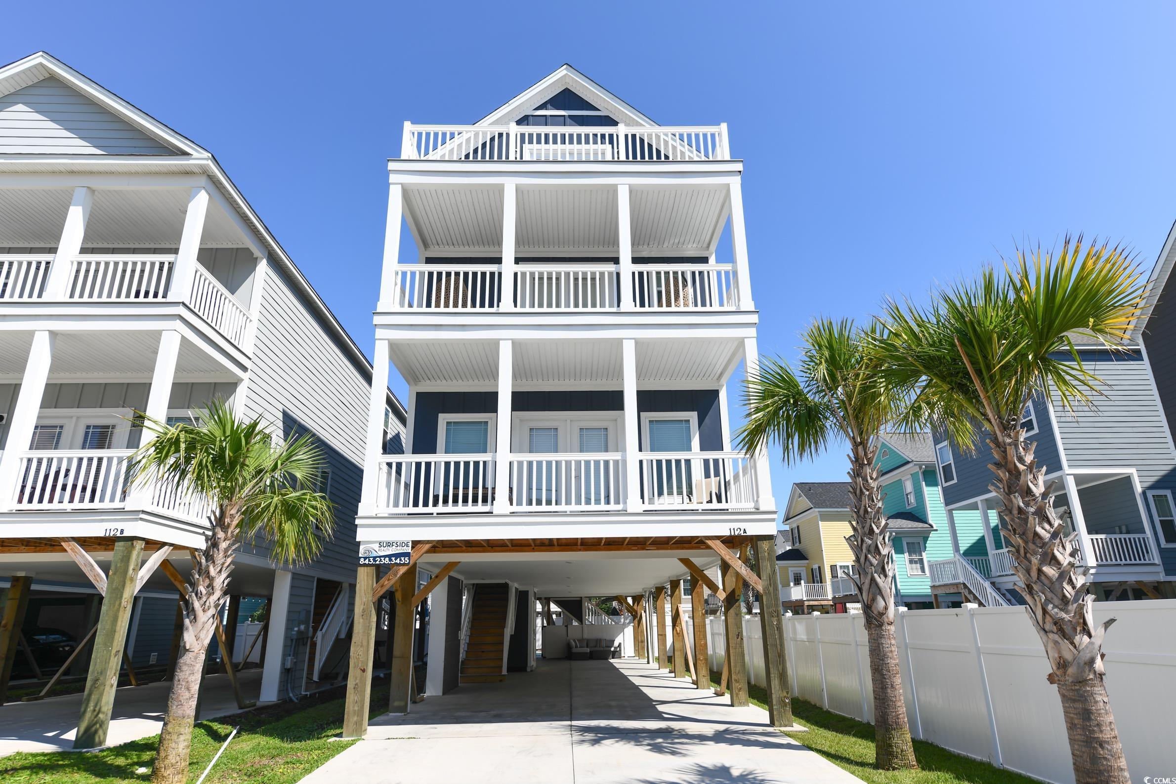 Image 1: Coastal home featuring a carport, a balcony, and d