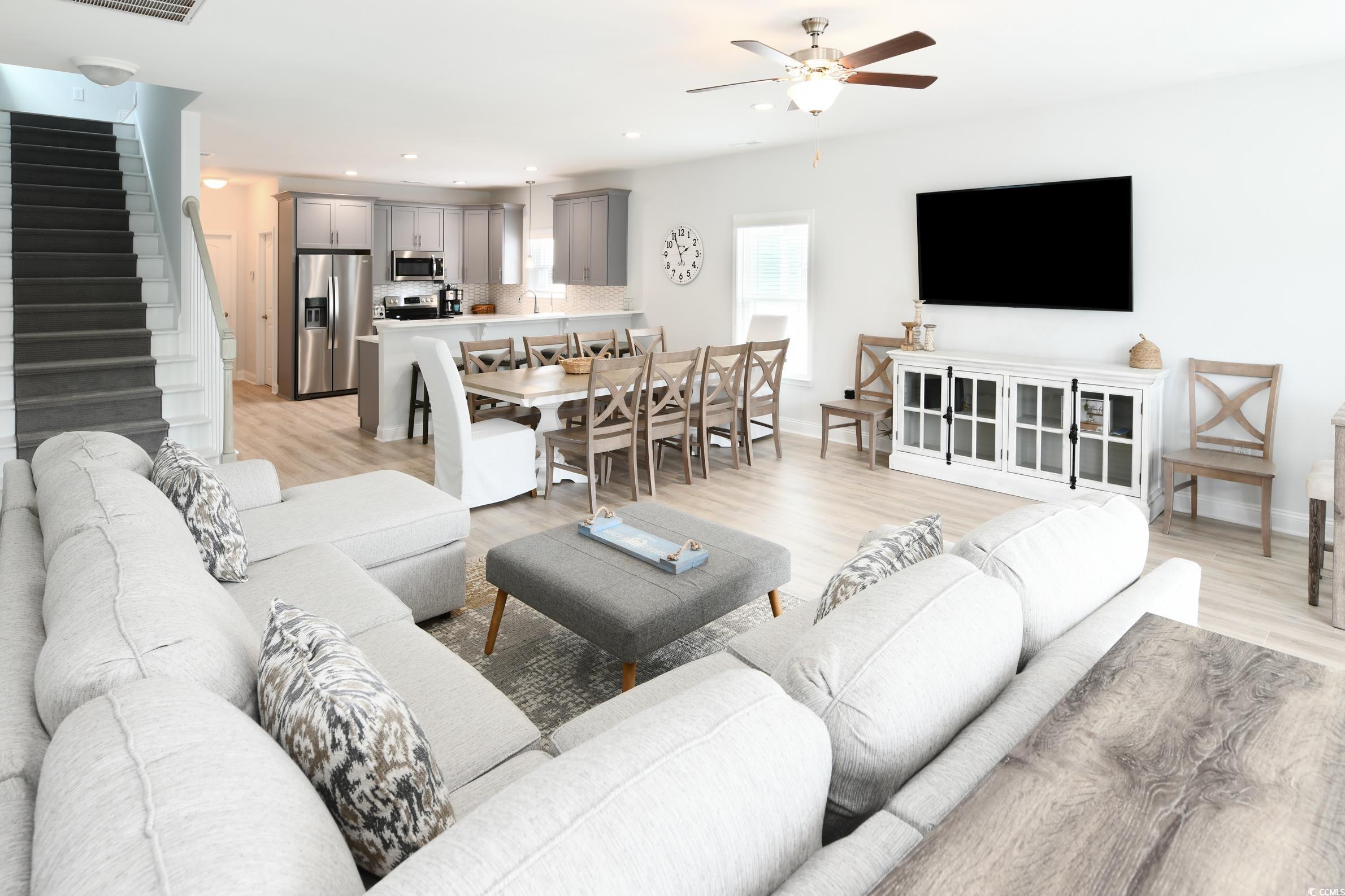 Image 2: Living area with stairs, light wood-style flooring