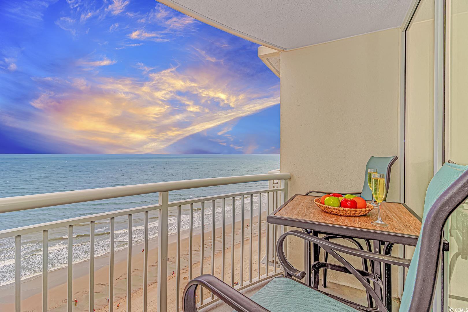 Image 3: Balcony at dusk featuring view of water and beach Image 3: Balcony at dusk featuring view of water and beach