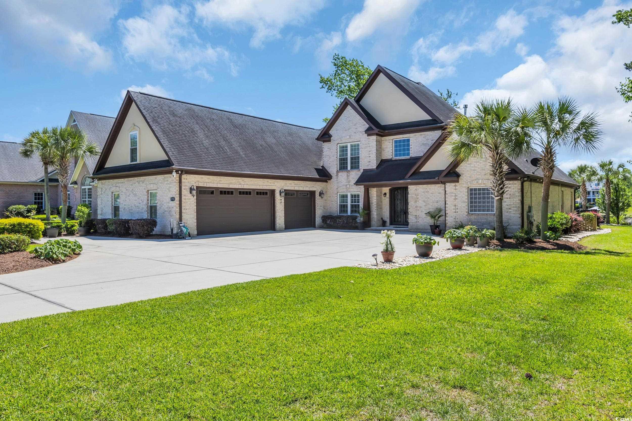 Image 2: View of front of house featuring a garage, brick s