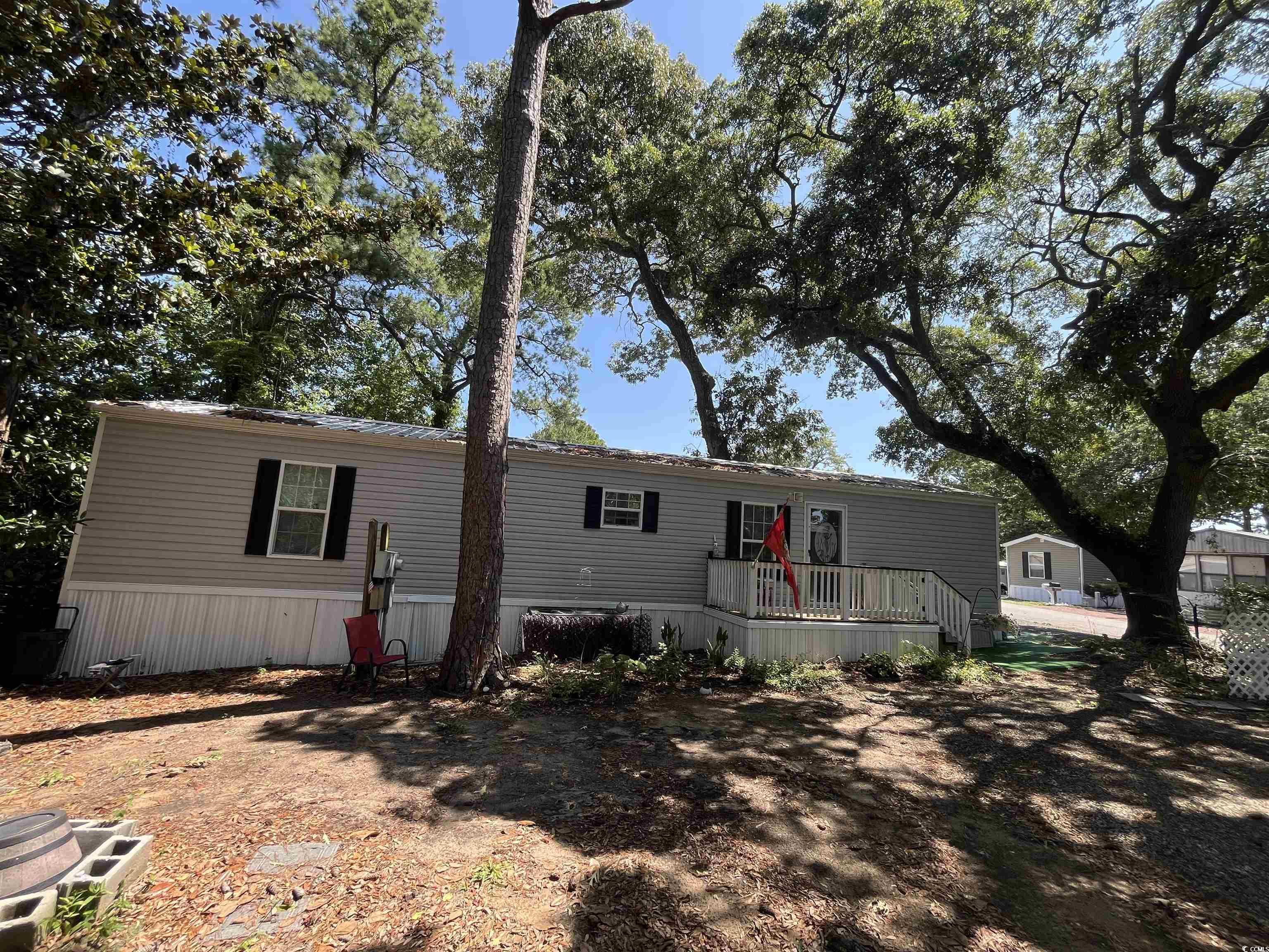 Image 1: View of front of house featuring a wooden deck