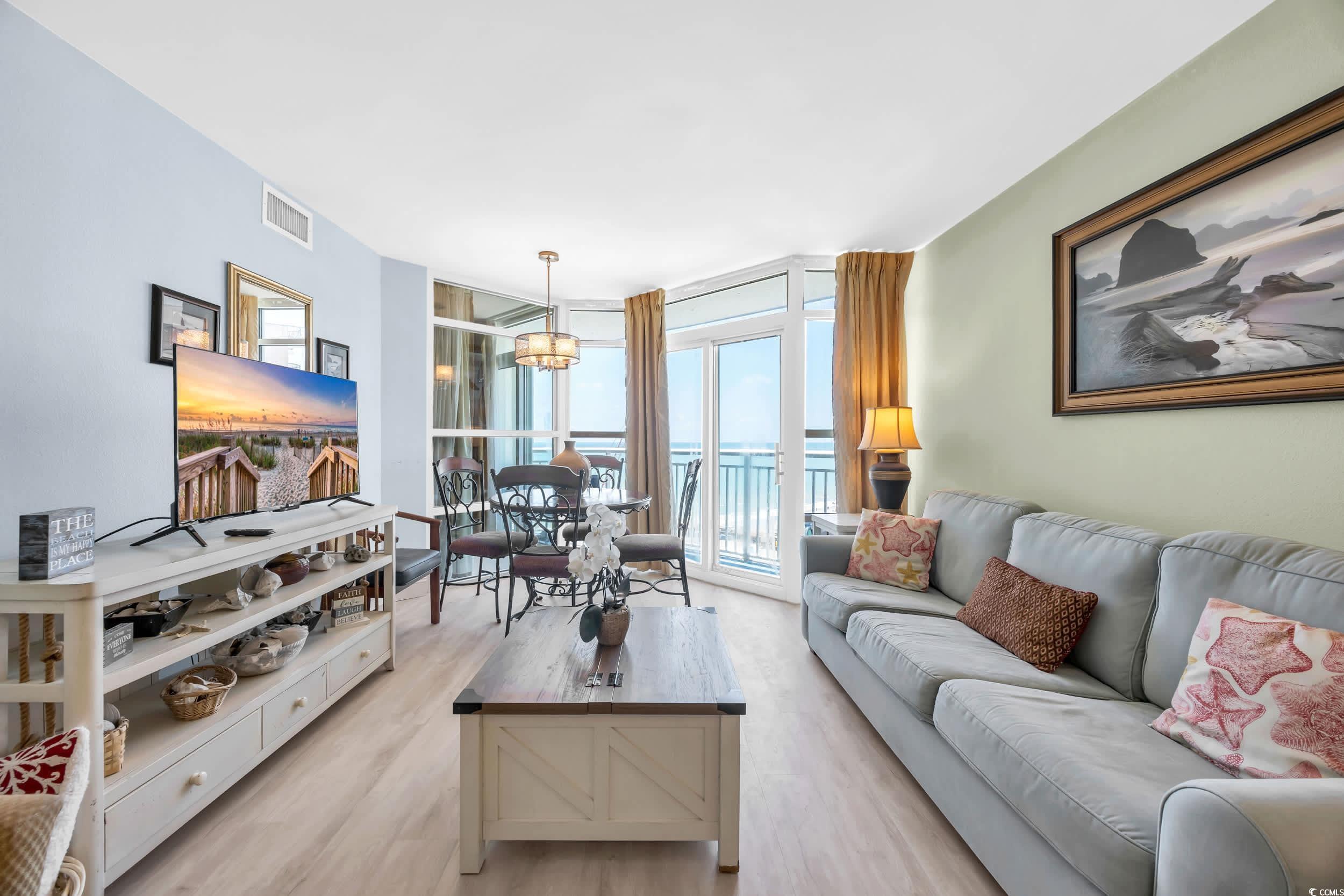 Image 3: Living room featuring a wall of windows, light woo