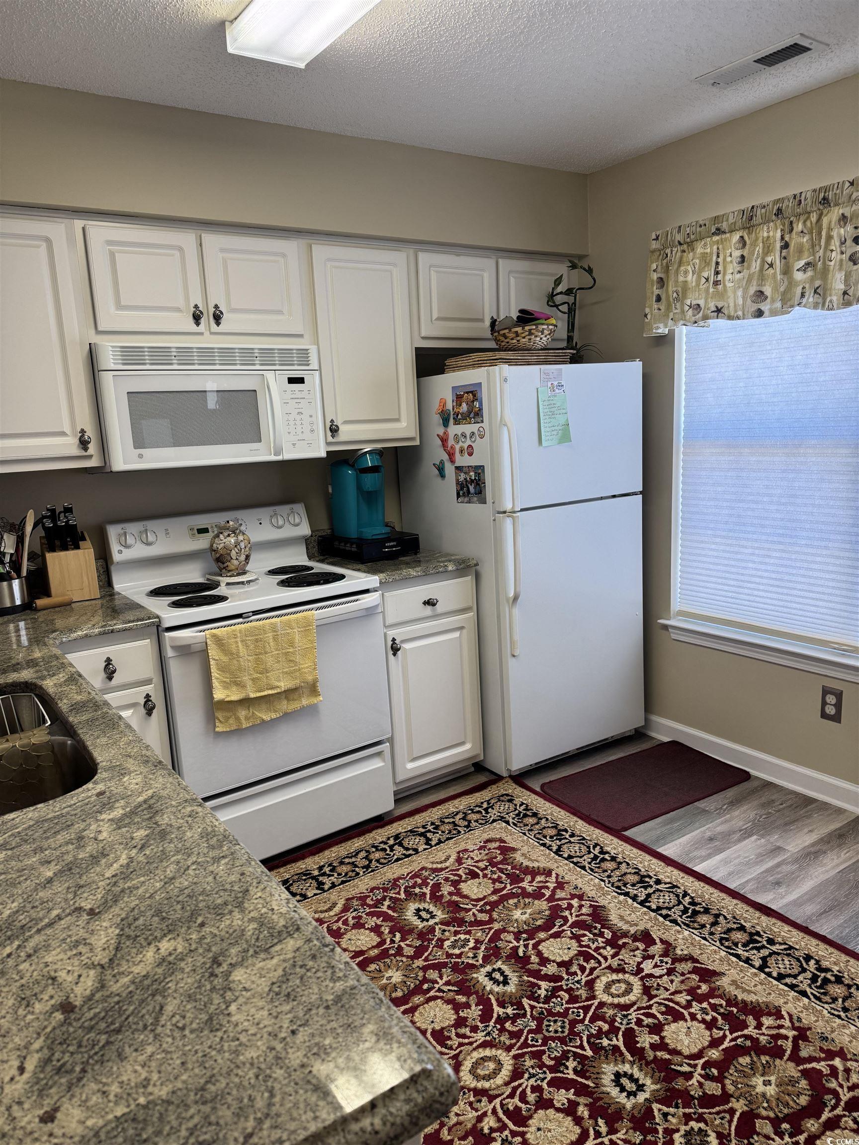 Image 4: Kitchen with white appliances, white cabinets, a t Image 4: Kitchen with white appliances, white cabinets, a t