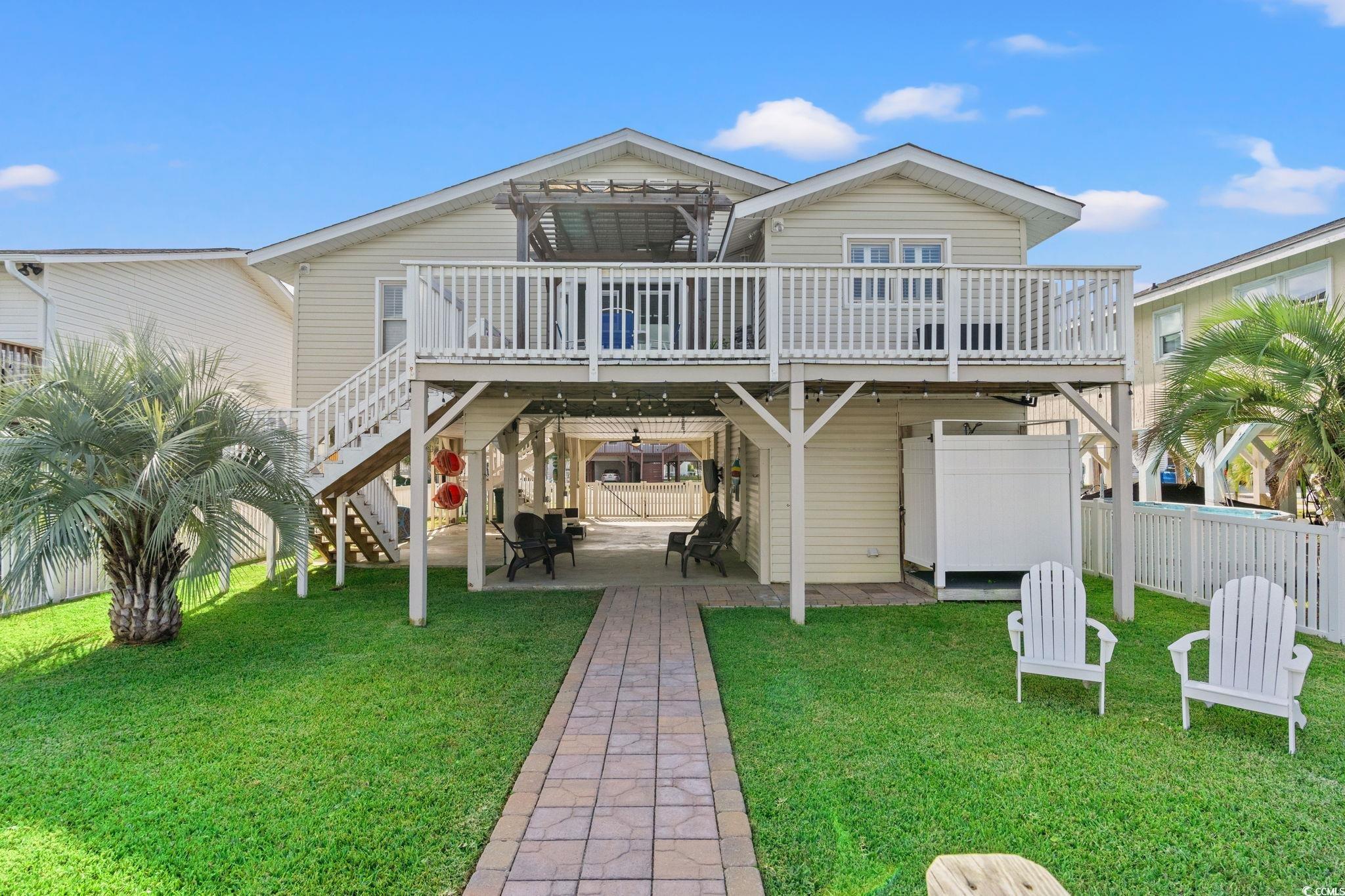 Image 3: Rear elevation shows elevated wood deck and large Image 3: Rear elevation shows elevated wood deck and large