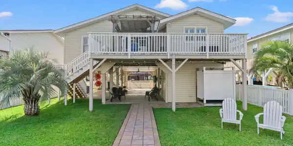 Image 3: Rear elevation shows elevated wood deck and large Image 3: Rear elevation shows elevated wood deck and large