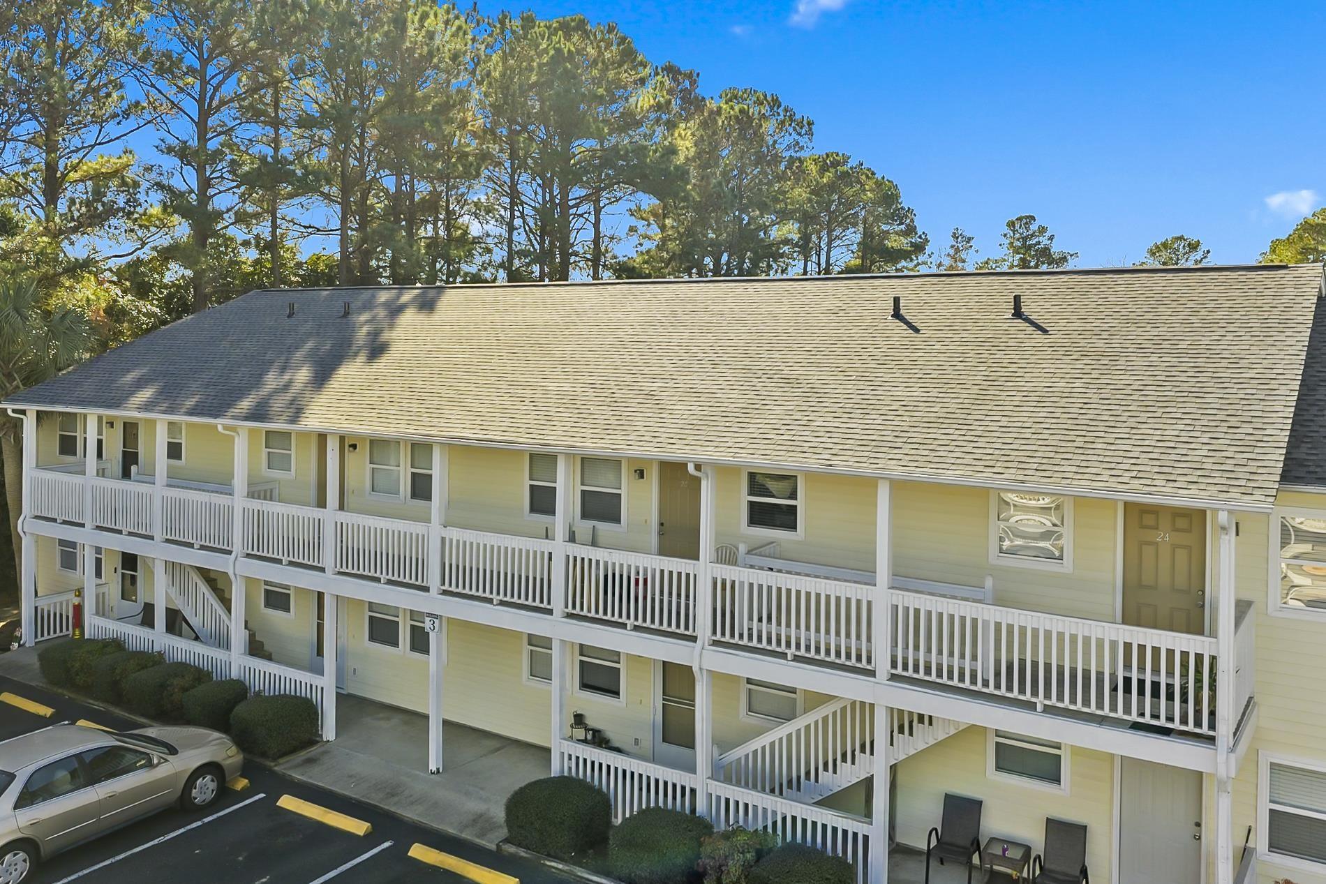 Image 2: View of building exterior with uncovered parking a