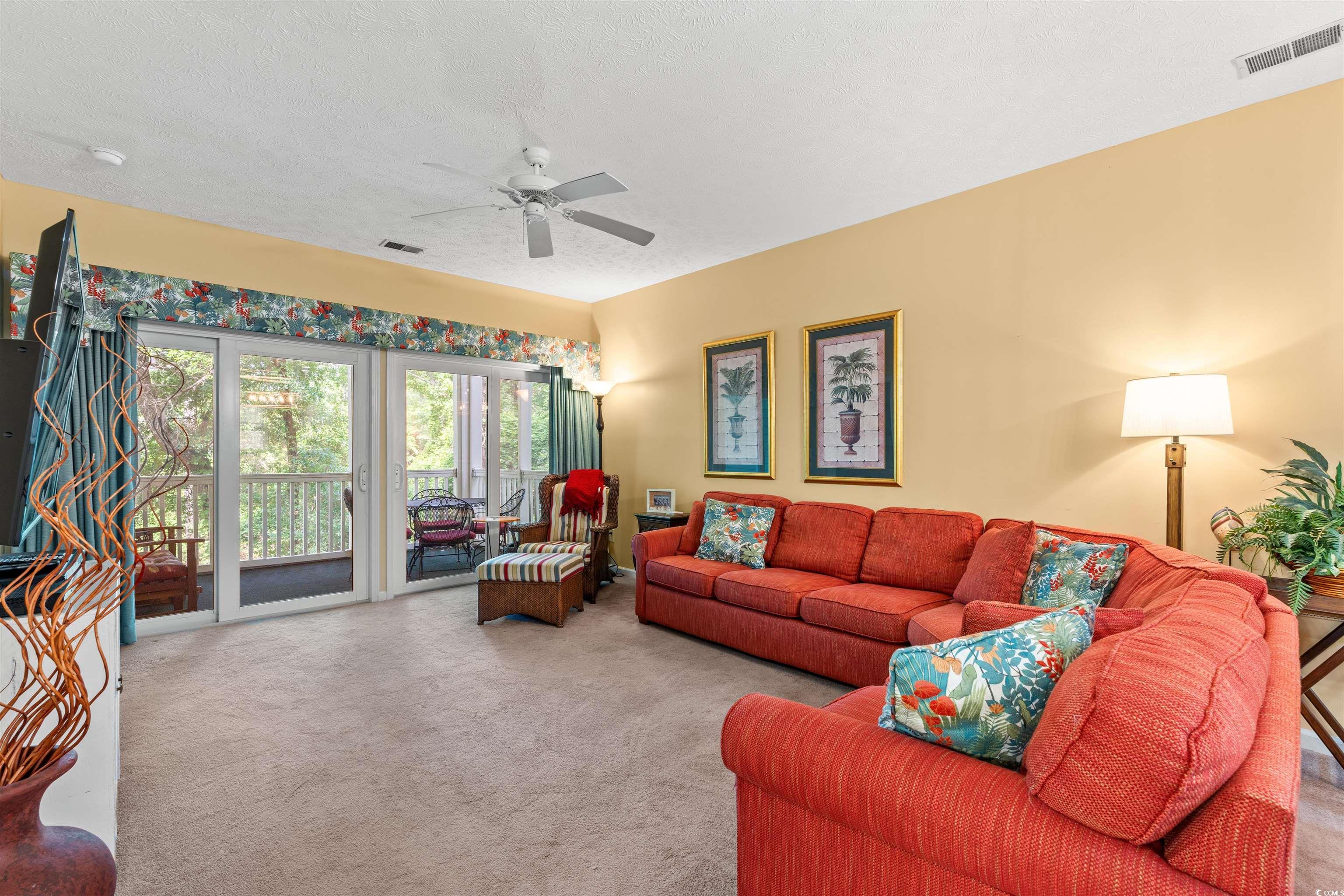 Image 2: Carpeted living room with a ceiling fan and a text Image 2: Carpeted living room with a ceiling fan and a text