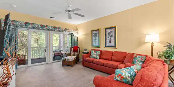 Image 2: Carpeted living room with a ceiling fan and a text Image 2: Carpeted living room with a ceiling fan and a text