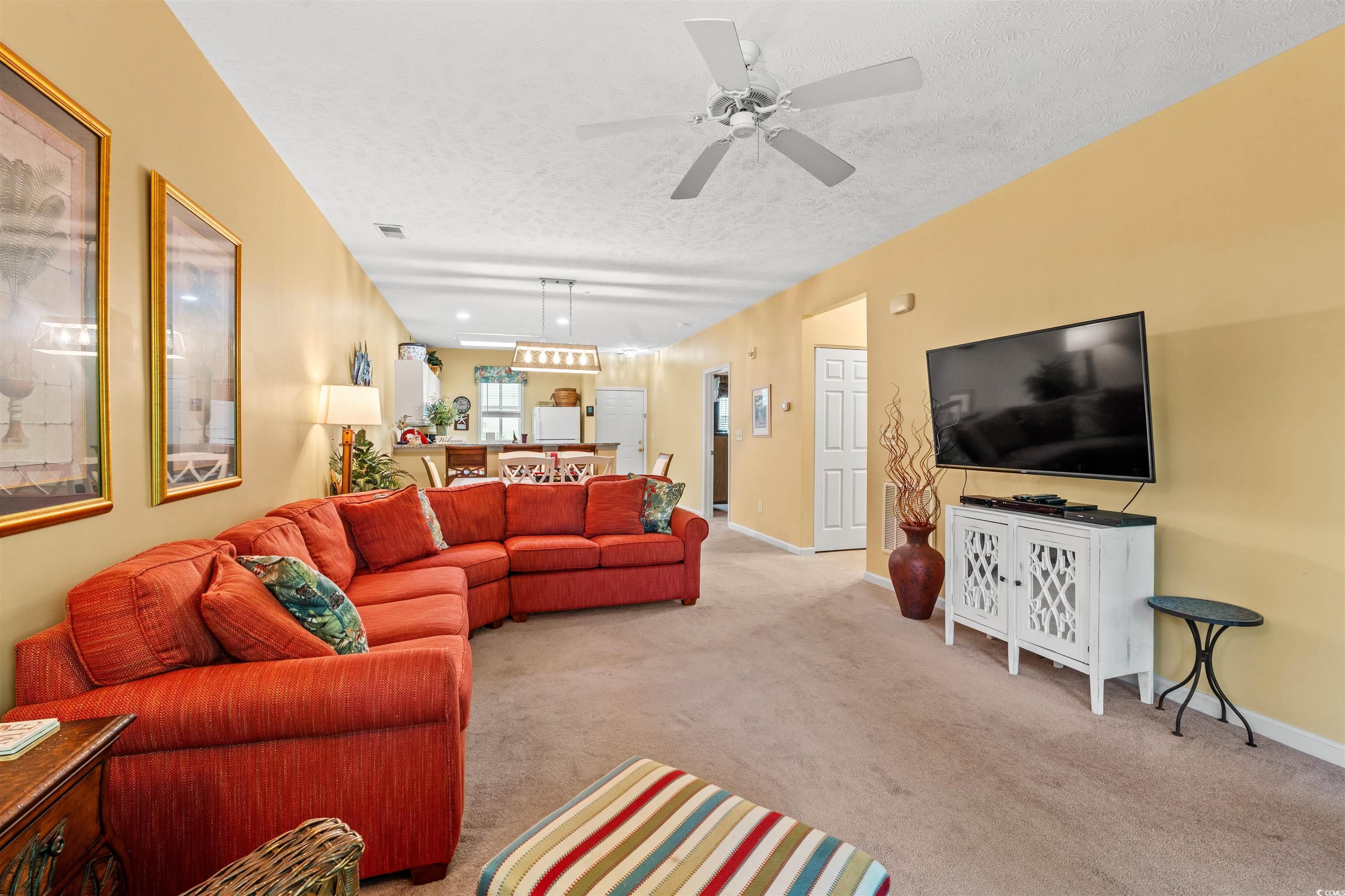 Image 4: Living area with a textured ceiling, carpet floors Image 4: Living area with a textured ceiling, carpet floors