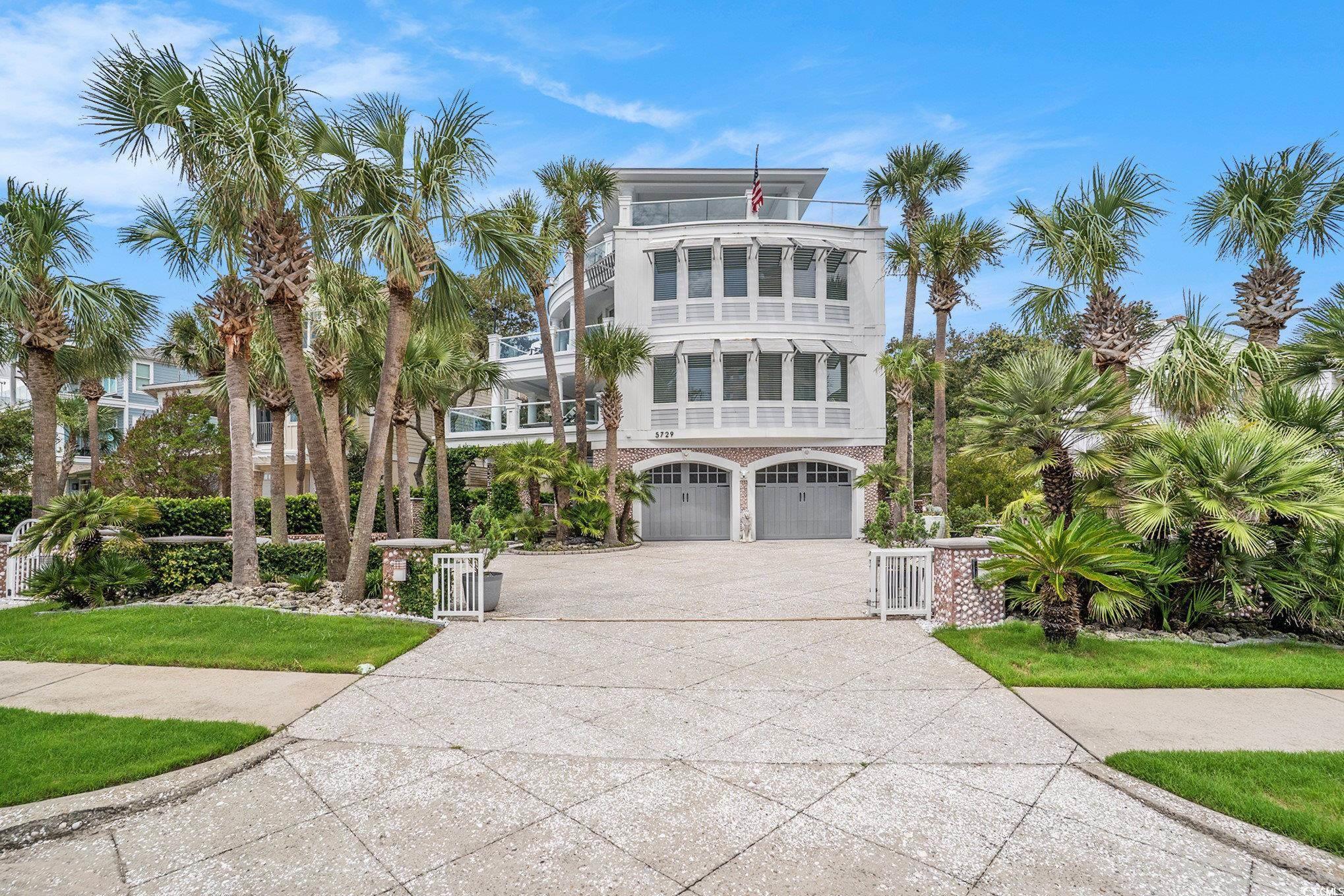 Image 1: View of front facade with concrete driveway, an at