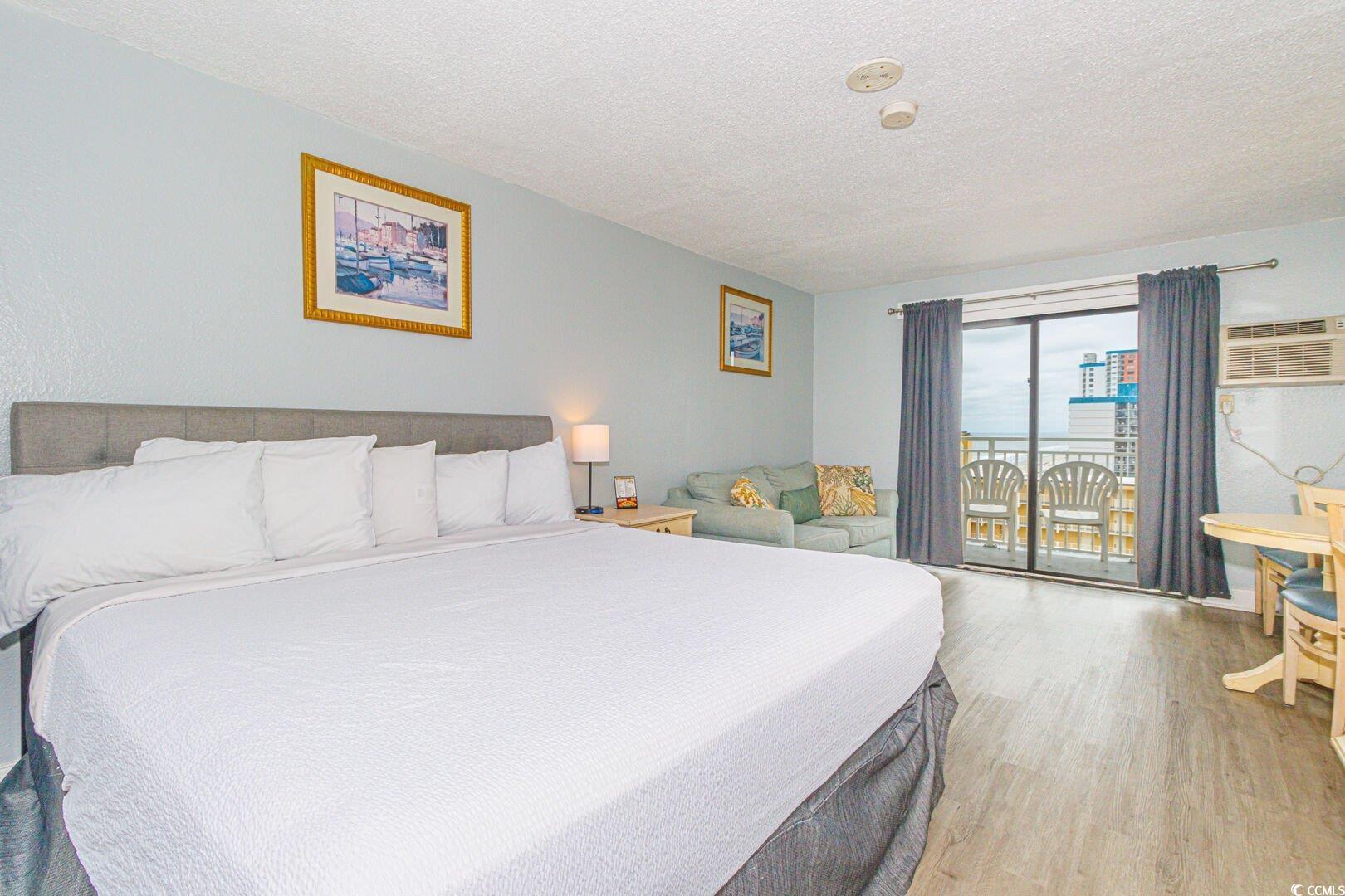 Image 2: Bedroom featuring wood finished floors, a textured