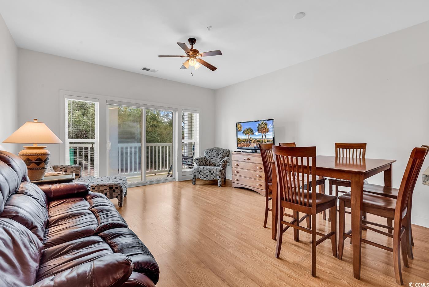 Image 3: Living area with light wood finished floors and a