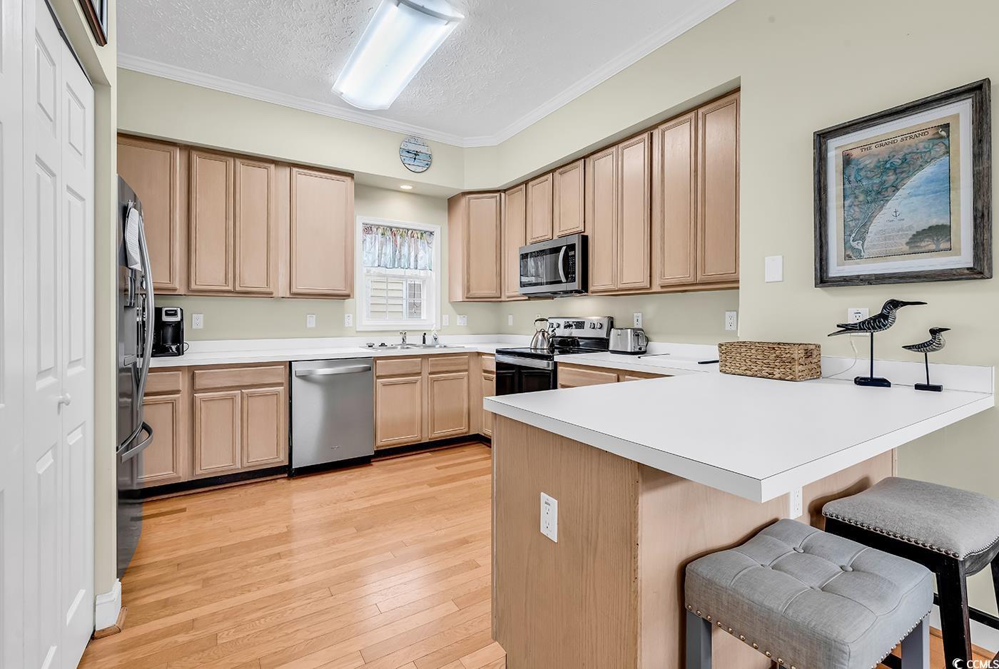 Image 2: Kitchen with stainless steel appliances, a peninsu