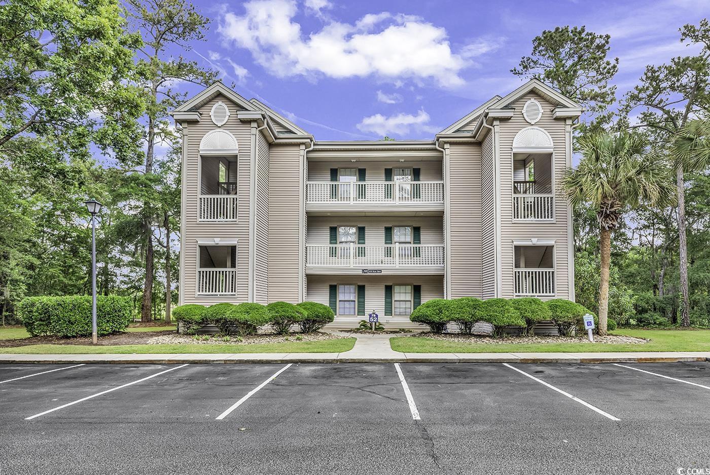 Image 3: View of building exterior with uncovered parking