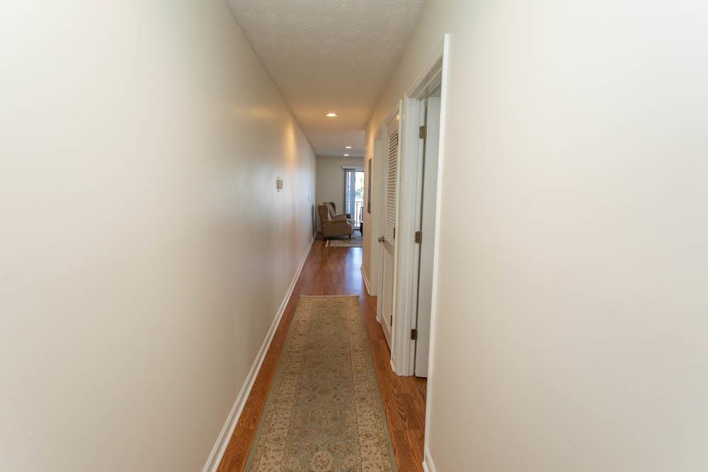 Image 4: Hall with wood finished floors, a textured ceiling