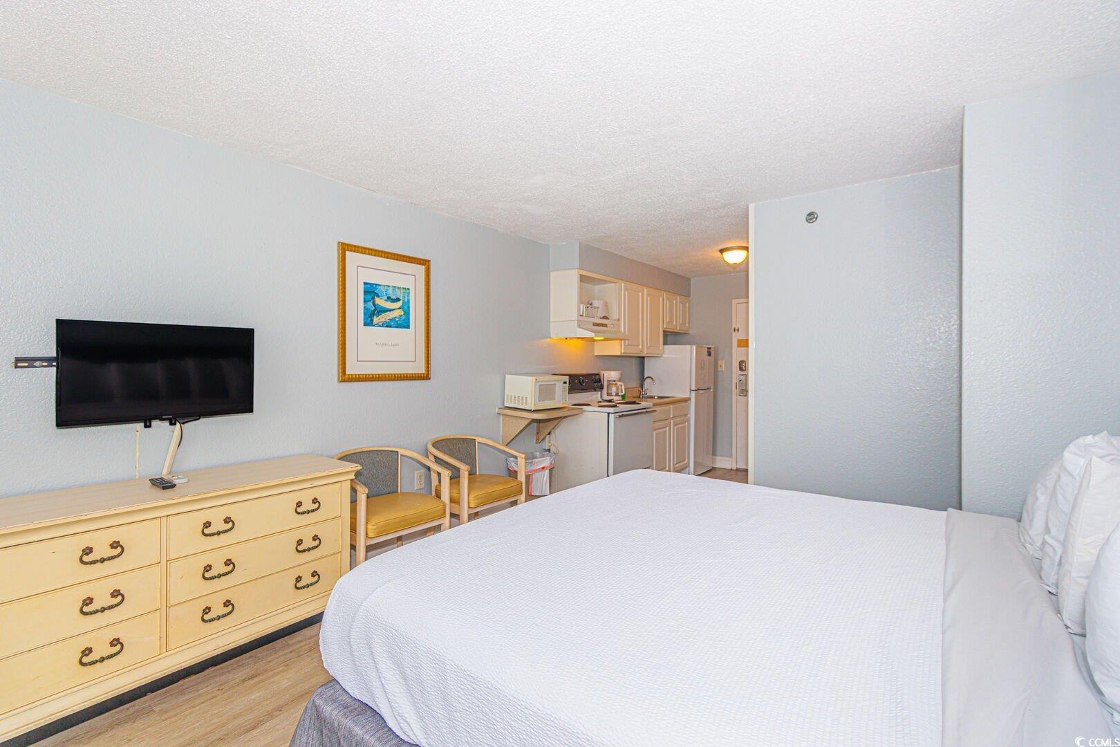 Image 3: Bedroom featuring light wood-style floors and a te