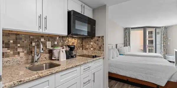 Image 3: Kitchen featuring white cabinets, light stone coun