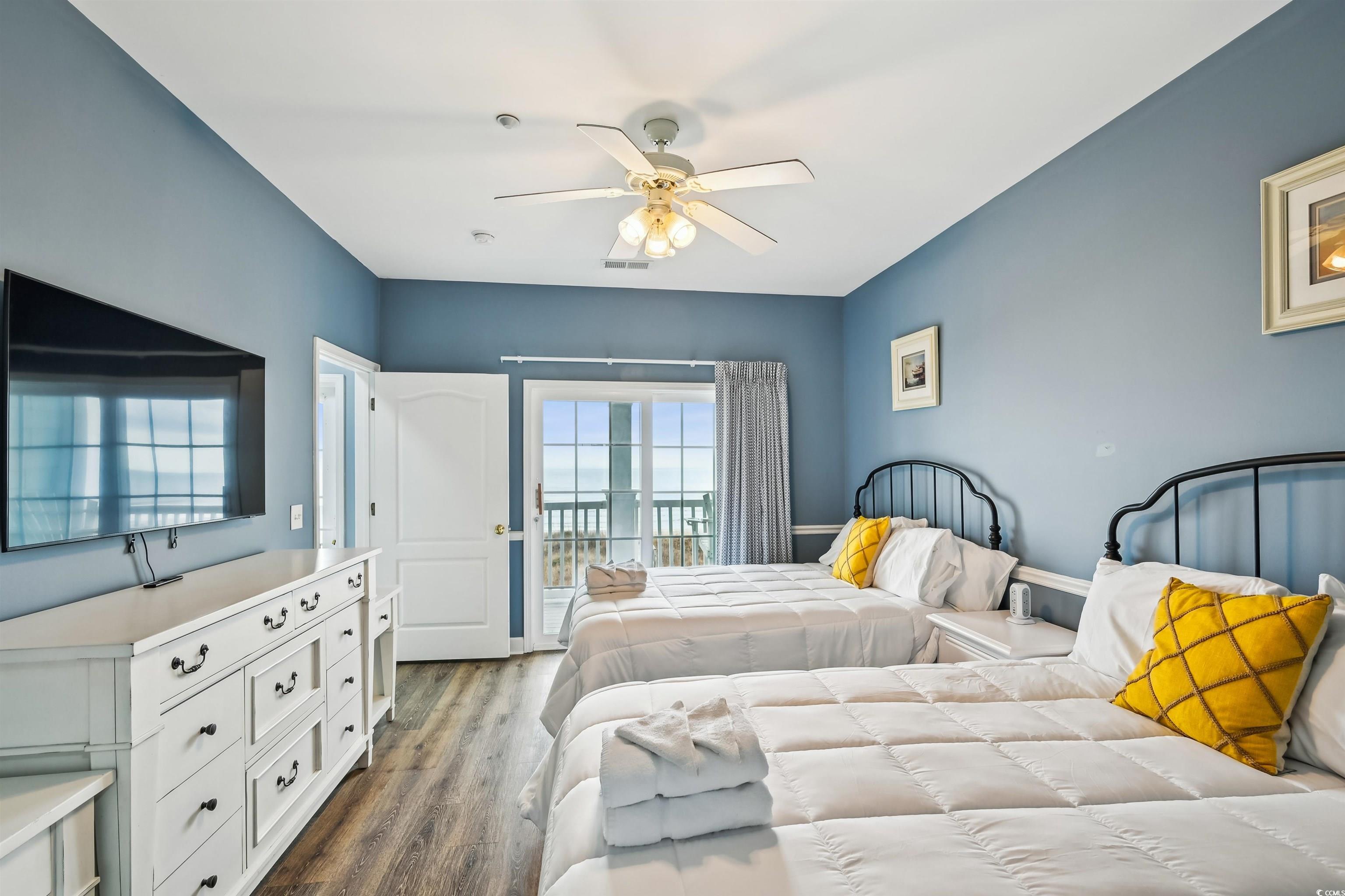 Image 3: Bedroom featuring access to exterior, dark wood-st