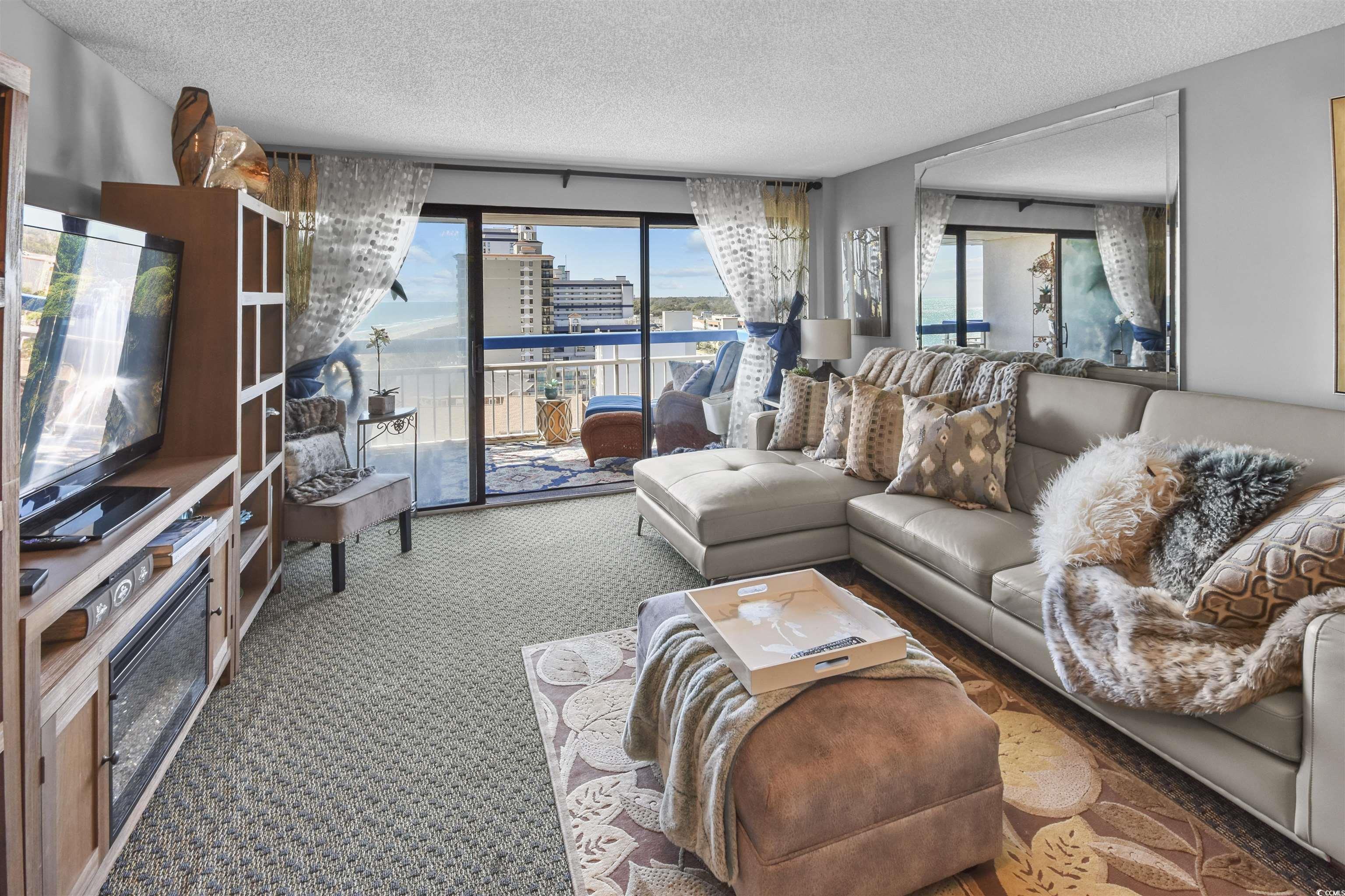 Image 2: Living room with a view of city, a textured ceilin