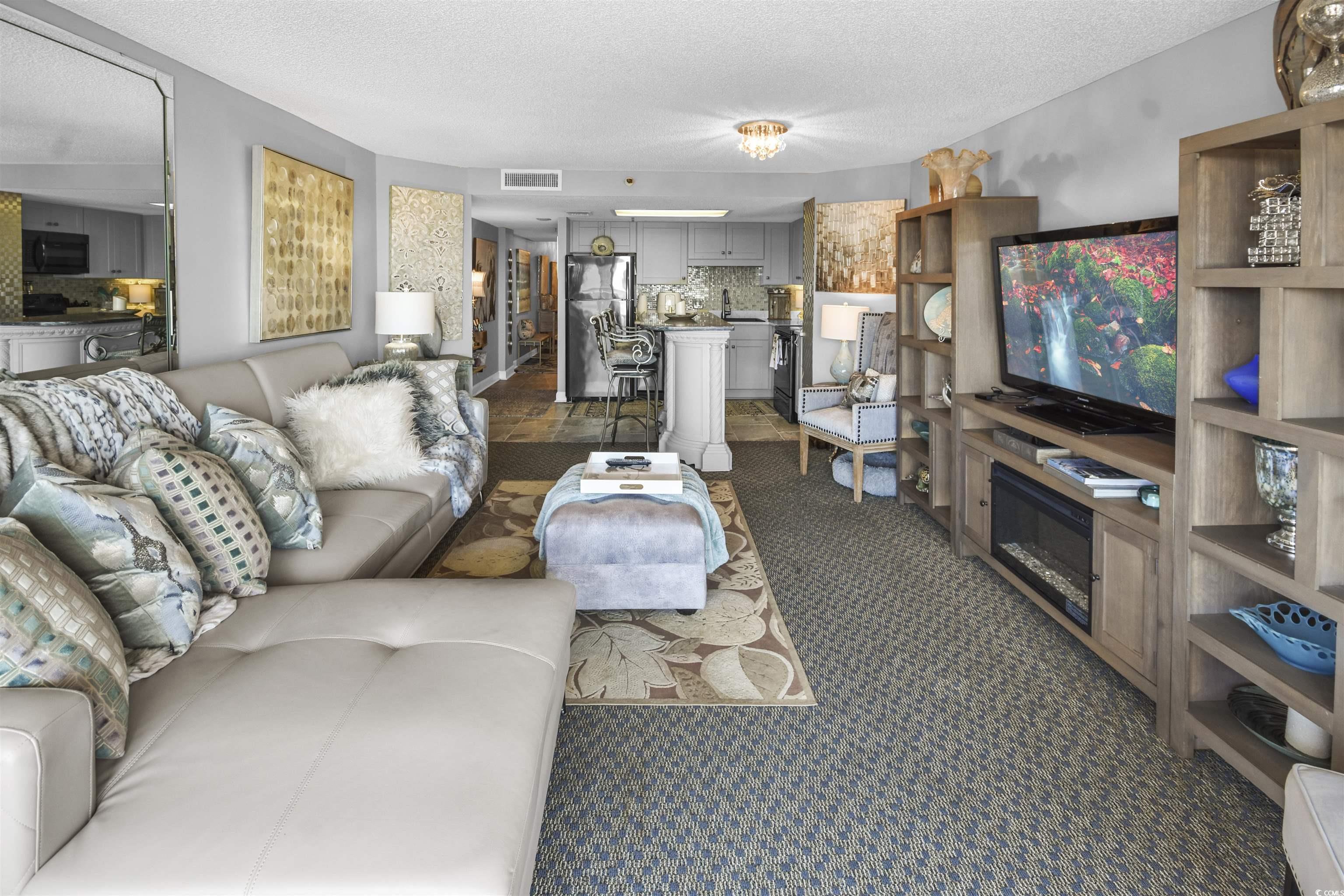 Image 3: Living room with visible vents, dark colored carpe
