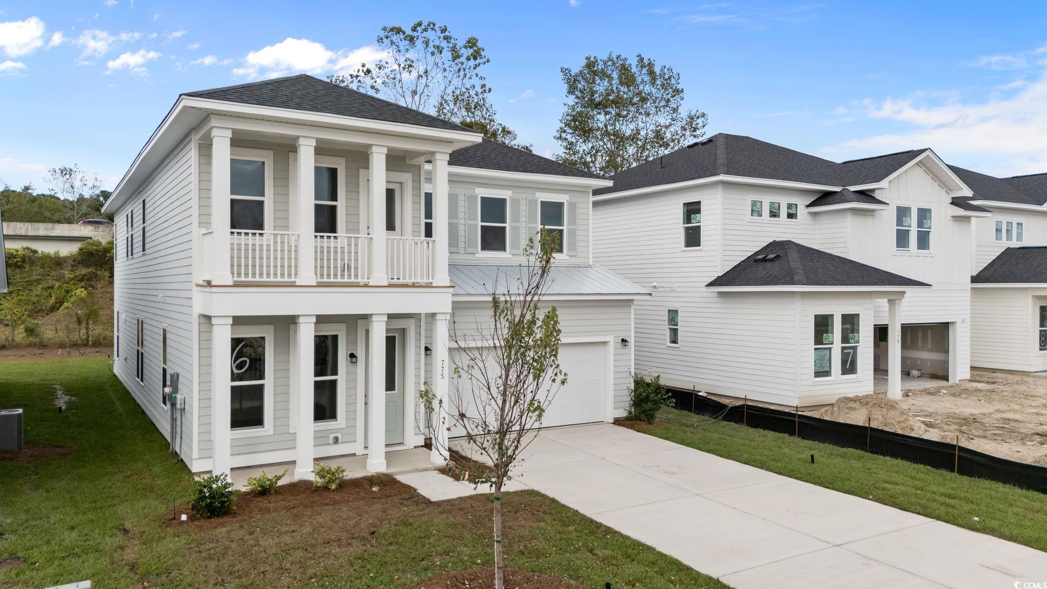 Image 3: View of front of home with a shingled roof, drivew