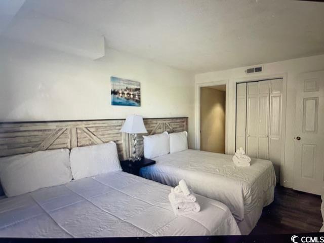 Image 4: Bedroom with visible vents, a closet, and wood fin