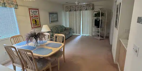 Image 2: Dining area with a textured ceiling, carpet floori