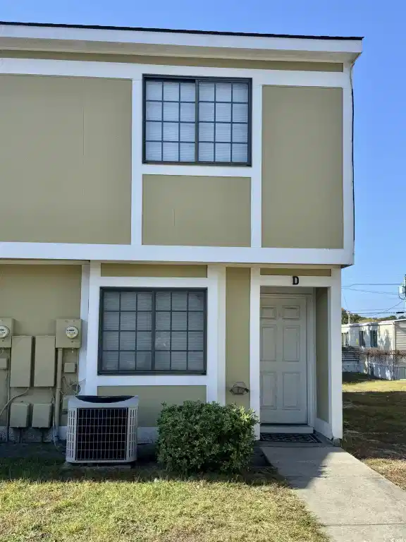 Image 1: View of front facade featuring stucco siding and a