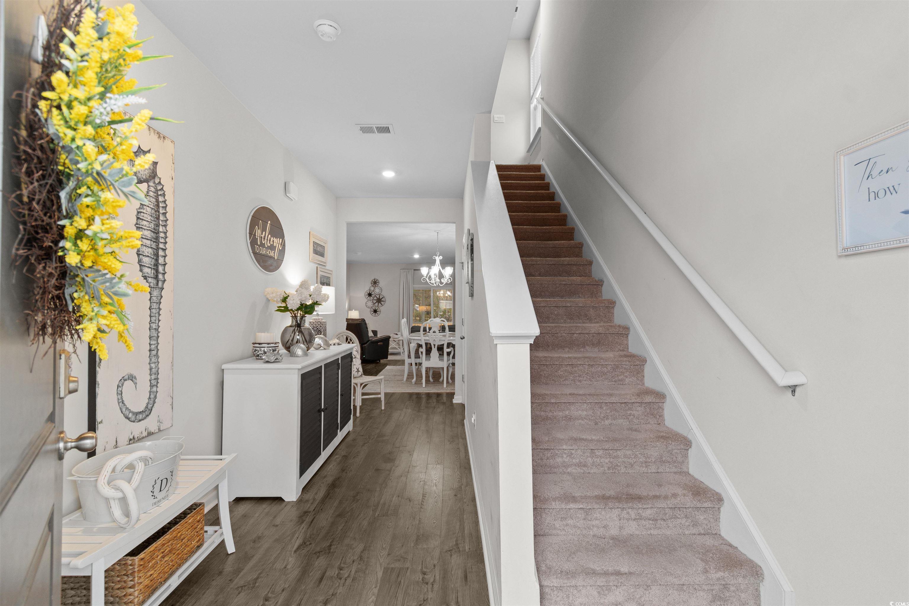 Image 2: Entrance foyer with dark wood-style floors, a chan
