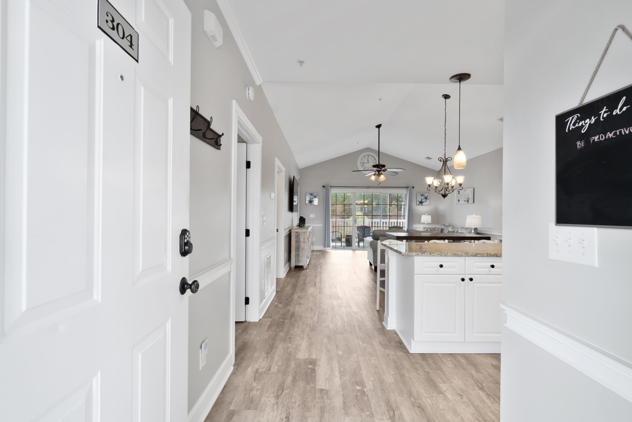 Image 2: Corridor featuring a chandelier, vaulted ceiling, Image 2: Corridor featuring a chandelier, vaulted ceiling,