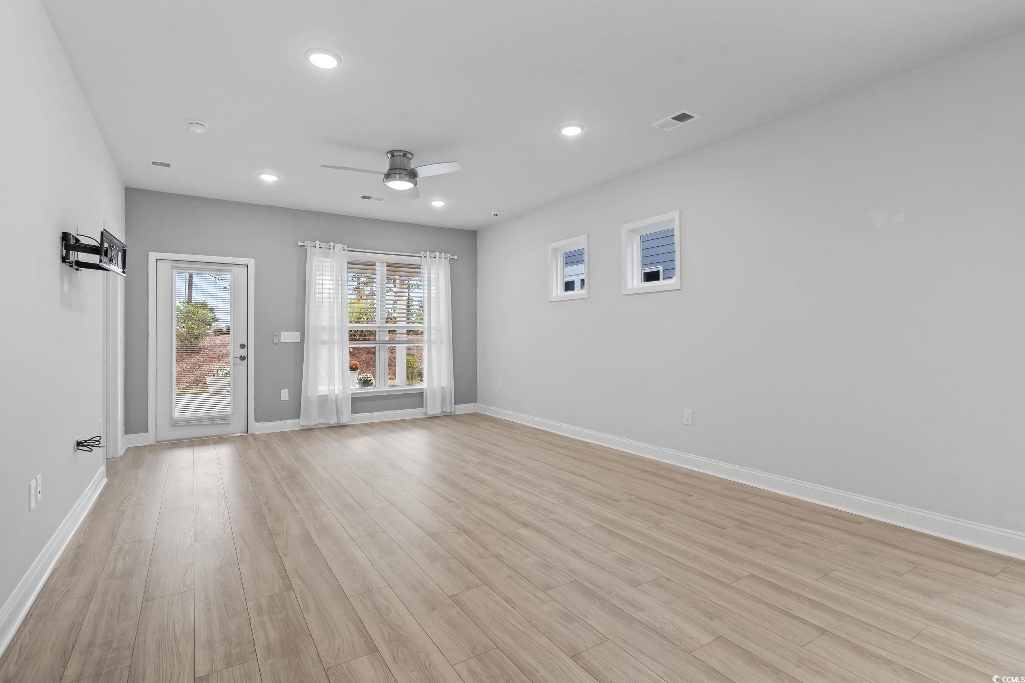 Image 3: Living/dining/kitchen room with light wood finishe